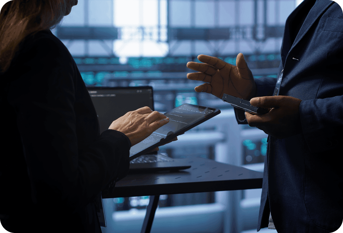 Consultants discussing digital strategies with tablets and laptops, highlighting collaborative digital transformation support.